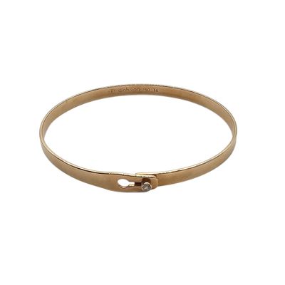 a close up of a gold bracelet on a white background