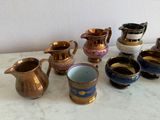 many different types of cups and pitchers on the table