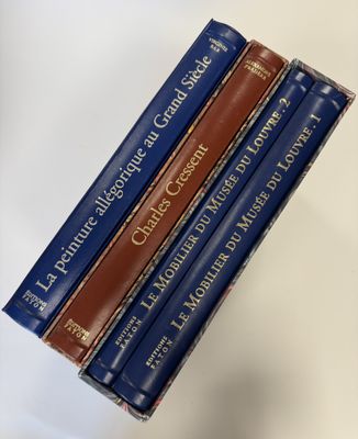 trois livres sont empilés sur une table