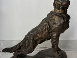 une statue représentant un chien assis sur un rocher
