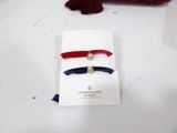 two red, white and blue hair ties with a gold heart charm