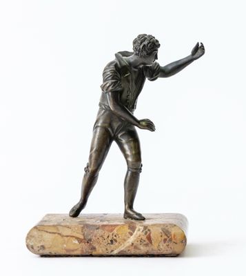 bronze statue of a man holding a tennis racquet on a marble base