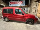 une camionnette rouge garée dans un garage, avec une pancarte en arrière-plan