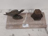 deux figurines d'oiseaux posées sur un socle en marbre