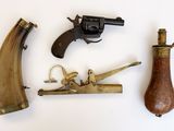 trois types d'armes à feu différents posés sur une surface blanche