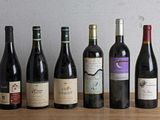 plusieurs bouteilles de vin sont alignées sur une table en bois