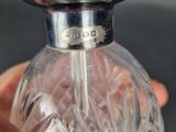 a person holding a small glass bottle with a silver top