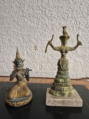 statue of a woman holding a staff next to a statue of a man holding a staff