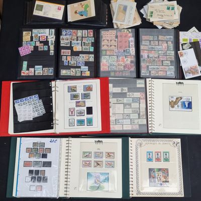 beaucoup de timbres posés sur une table, sur laquelle se trouve un classeur