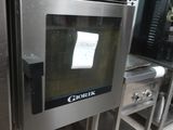 un four en acier inoxydable dans une cuisine dotée de nombreux plans de travail