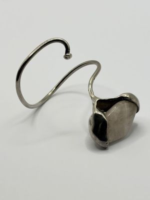 a close up of a metal hook with a heart shaped object on it