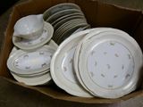 many plates and bowls in a box on the floor