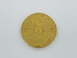 a close up of a gold coin on a white surface