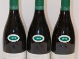 trois bouteilles de vin sont alignées sur une table