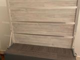 a bed with a wooden headboard on wheels in a room