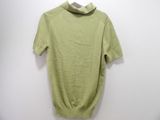 green turtle neck sweater on a hanger against a white wall