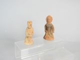 two figurines sitting on a clear stand