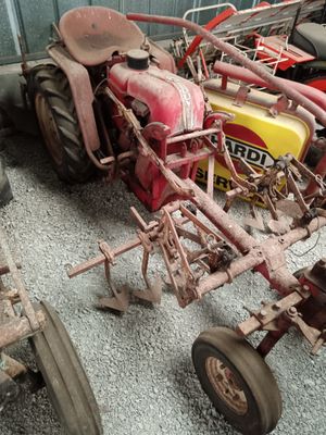 a red tractor that is parked next to a yellow tractor
