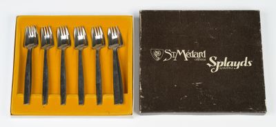 four forks and a knife in a box on a white surface