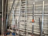 several ladders leaning against a wall in a warehouse