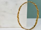 une image représentant un bracelet en or posé sur un bloc de marbre