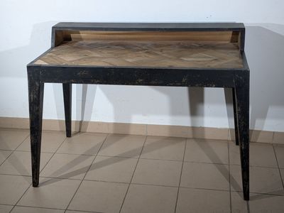 a black table with a wooden top on a tiled floor