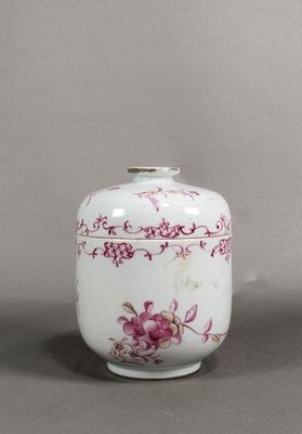 un vase blanc orné de fleurs roses, posé sur une table
