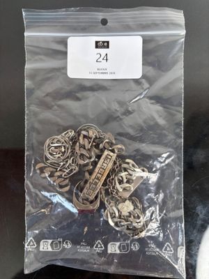 a bag of silver metal charms sitting on a table