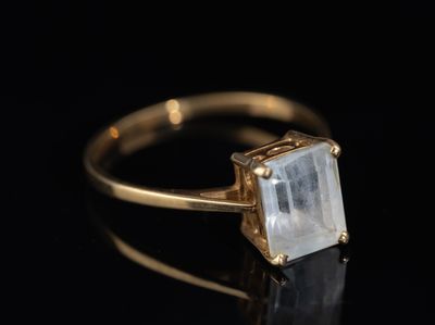 un gros plan d'une bague en or sertie d'une pierre blanche