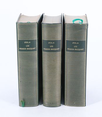 trois livres sont empilés sur une surface blanche