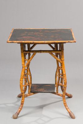 an old wooden table with a black top on a gray background