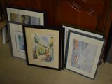 three framed pictures on the floor next to a dresser