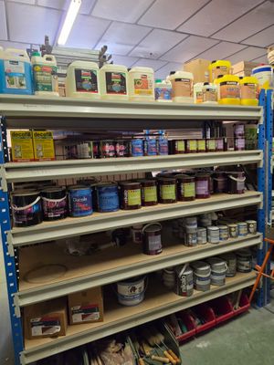 de nombreuses étagères remplies de peinture et d'autres articles dans le magasin