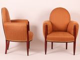 pair of orange upholstered chairs with wood legs and arms