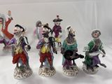 five figurines of people dressed in different costumes