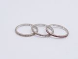 three silver rings on a white surface