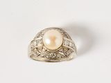an image of a pearl and diamond ring on a white surface