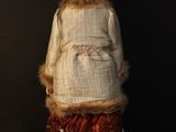 doll of a woman in a fur coat and skirt with a red hat