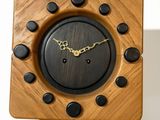a wooden clock on a tripod stand with a clock face