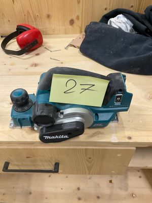 une petite raboteuse posée sur une table en bois