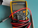 a multimeter and a pair of wires on top of a table