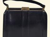 a black purse with a gold clasp on the handle