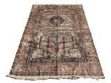 un tapis persan ancien avec un motif floral et des franges