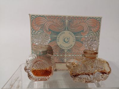 une table en verre sur laquelle est posée une boîte de parfums