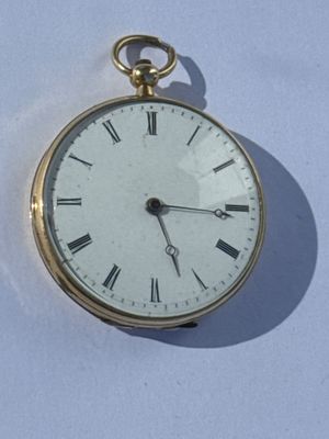 a gold pocket watch with roman numerals on the face