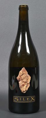 a bottle of wine with a piece of gold on it