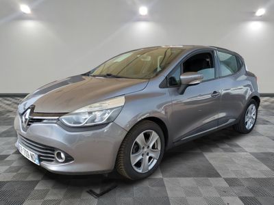 Une voiture argentée est garée dans une pièce au sol à carreaux.