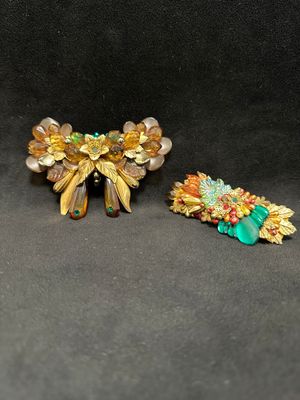 two pieces of brooches are sitting on a black surface