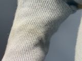 a close up of a person wearing a sweater and a pair of gloves