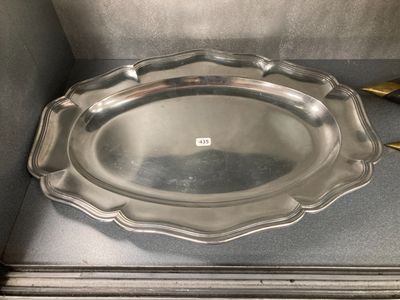 une assiette en argent posée sur un comptoir, à côté d'une paire de ciseaux